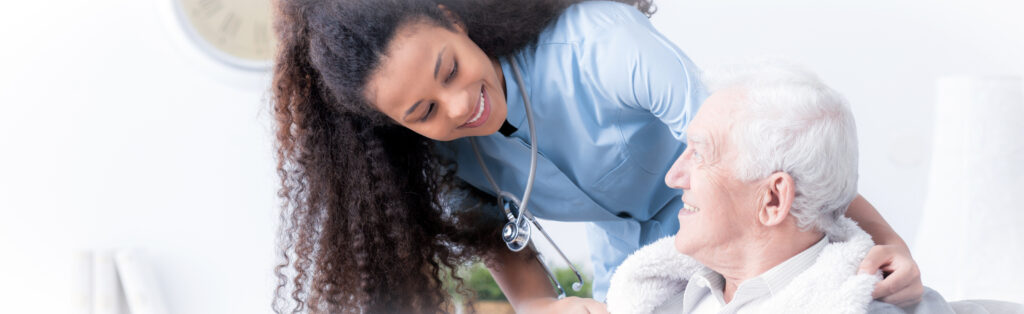 Panorama of happy caregiver supporting smiling elderly man in the nursing house